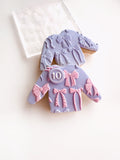 Decorative cookies shaped like dresses with bows on a white background