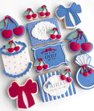 Decorative cookies with blue, red, and white icing, featuring cherry designs and text.