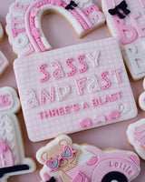 Decorative cookies with text and shapes on a pink background